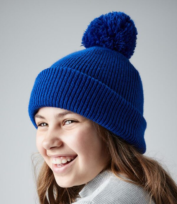 Double layer knit. Cuffed design. Self colour pom pom with highly reflective fibres. Tear out label.