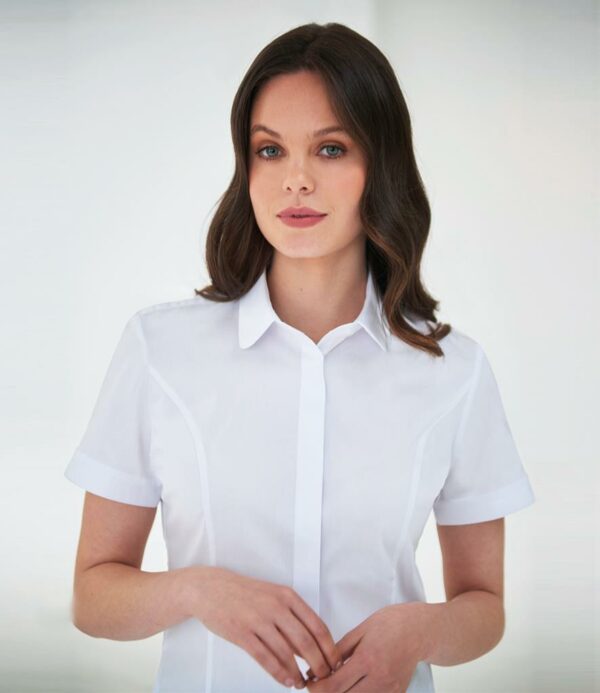 Easy care stretch fabric. Semi-fitted. Rounded collar. Concealed placket. Single yoke. Sleeve vent. Princess seams. Curved hem.