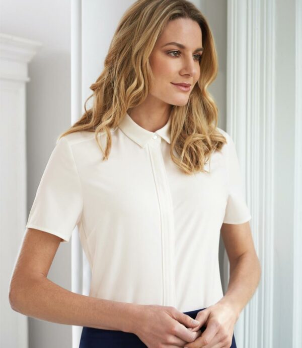 Easy care stretch fabric. Narrow collar. Concealed placket with button detail. Central back pleat. Straight hem.
