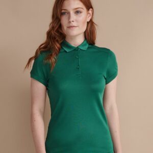 Moisture wicking fabric. Modern ladies fit. Flat knit collar. Front and back shoulder yoke detail. Three self colour button placket. Fitted sleeves with ribbed cuffs. Twin needle hem. Cut out label.