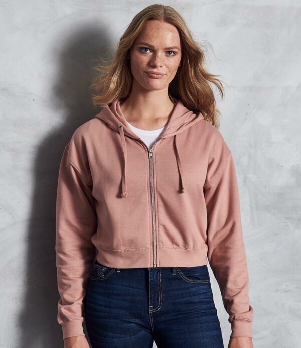 Soft cotton faced fabric. Brushed back fleece. Drop shoulder style. Ladies relaxed fit. Double fabric hood with flat lace drawcord. Full length metal YKK zip. Cropped length. Ribbed cuffs and hem. Twin needle stitching. Tear out label.