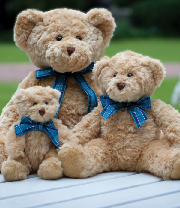 Light brown coloured bear with blue tartan ribbon. Contrast pads on paws and feet.