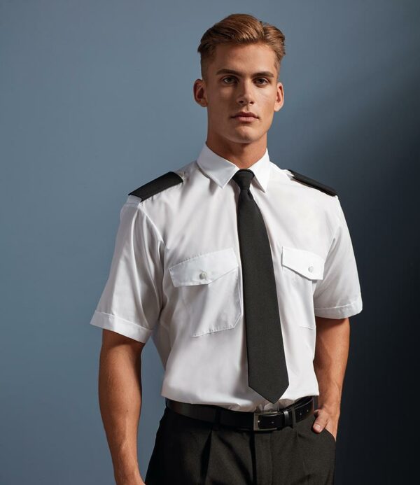 Easy care fabric. Stiffened collar. Epaulette tabs. Two chest pockets with button down flaps. Back yoke. Straight hem.