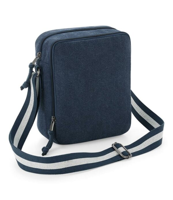 Two tone webbing adjustable shoulder strap. Main zip compartment. Front zip pocket. Tear out label. Capacity 3.5 litres.