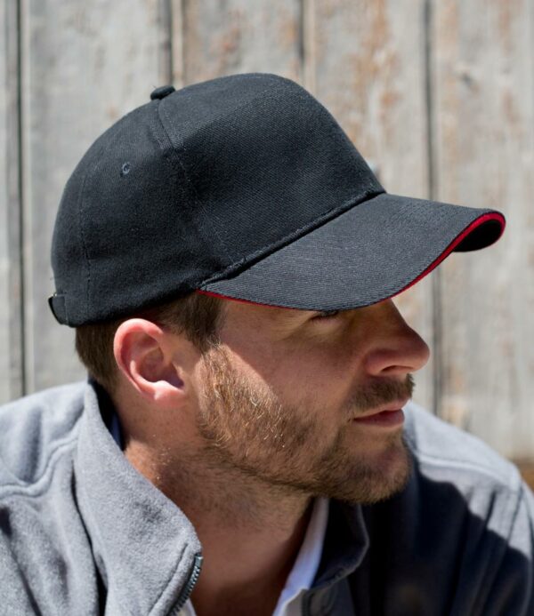6 panel. Stitched eyelets. Pre-curved peak. Contrast sandwich peak. Fabric size adjuster with antique brass buckle.