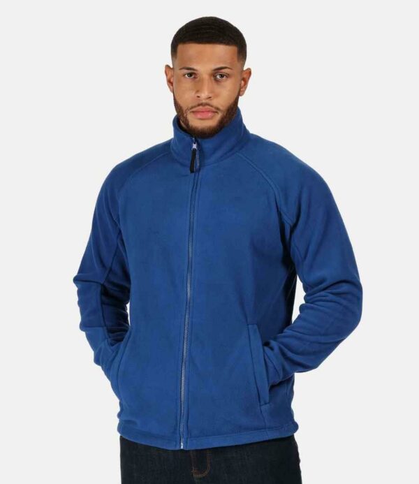 Unlined. Taped neck. Locker patch. Raglan sleeves. Full length zip. Two front zip pockets. Fleece cuffs. Double stitch detail. Open hem with adjustable drawcord. Interactive style. Cut out label (some colours in transition).