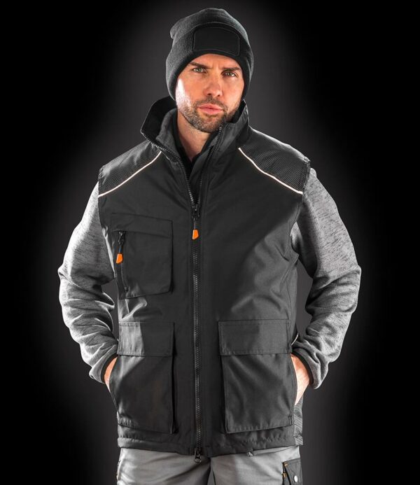 Polyester padding. 210T polyester taffeta diamond quilted lining. Waterproof 2000mm with critically taped seams. Windproof. Soft feel tricot lined collar. Full length zip with inner zip guard. Deep armholes with elasticated weather protectors. Right chest zip pocket. Inner pocket. Front patch pockets with side handwarmer entry. Dobby design contrast panelling. Reflective piping. Access for decoration. Includes 4 coloured zip pulls.